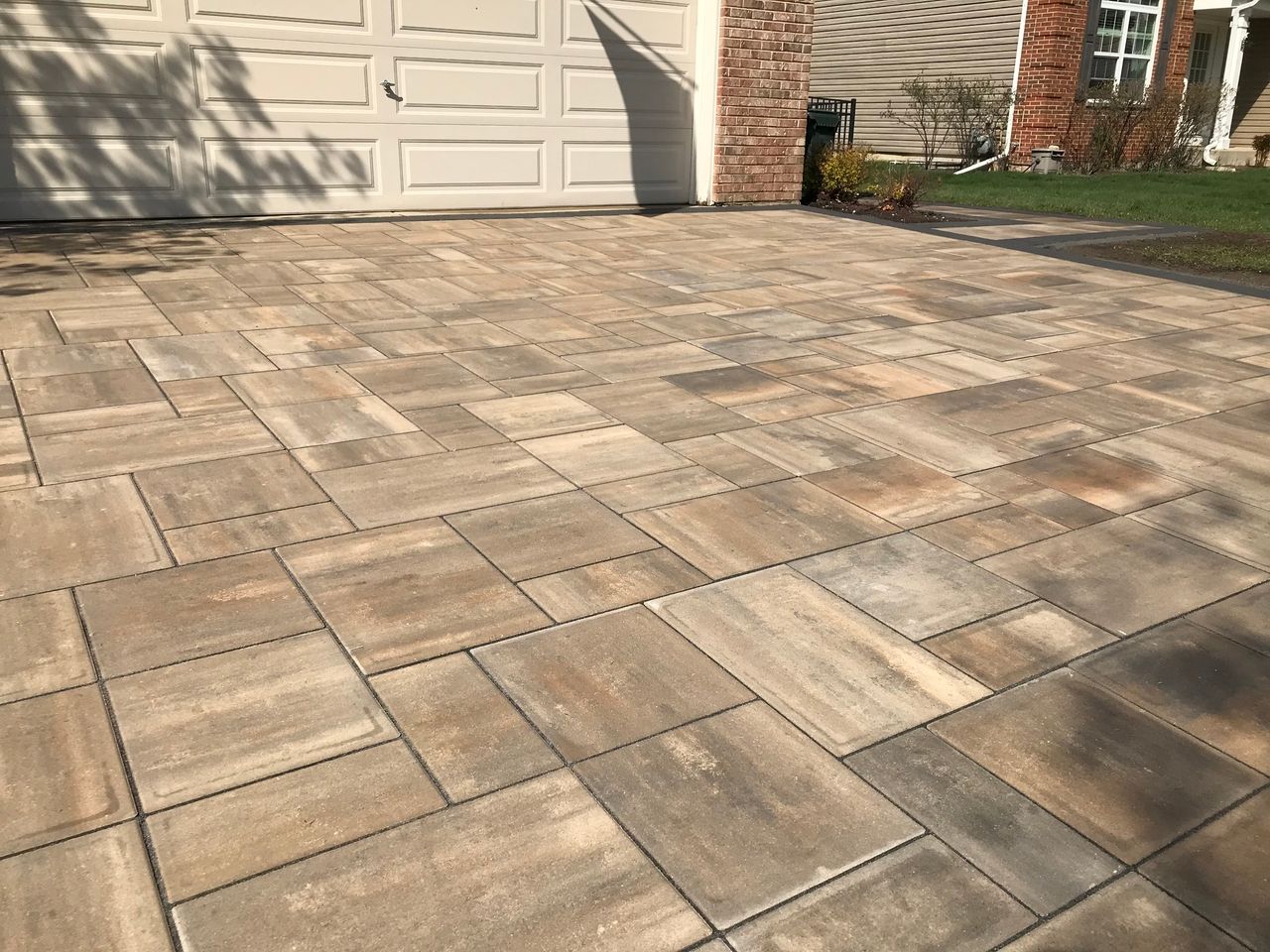 Large-format brick paver driveway installed on a compacted base in front of a garage in the Chicago suburbs