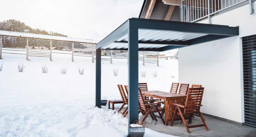 Hard top pergola protecting patio from snow